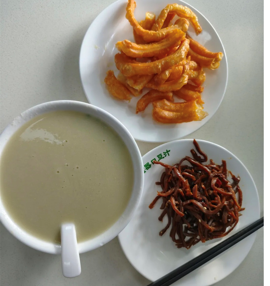 A classic Beijing breakfast experience: douzhi paired with crispy jiaoqian and tangy pickled vegetables